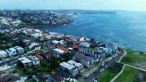 Drone-aerial-landscape-view-over-South-Coogee-headland-housing-units-buildings-Maroubra-Sydney-CBD-skyline-ocean-Australia