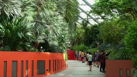 Turistas-Deambulando-Por-El-Invernadero-De-Cristal-Con-Cúpula-De-Flores-En-Los-Jardines-Junto-A-La-Bahía-Con-Variedad-De-Flores-Y-Plantas-En-Exhibición,-Toma-Estática