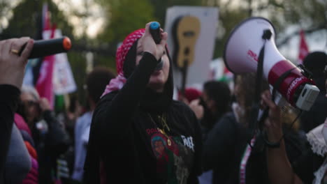 Un-Grupo-De-Mujeres-árabes-Con-Megáfonos-Y-Micrófonos-Encabezan-Una-Ovación-Entre-Una-Gran-Multitud-De-Manifestantes.