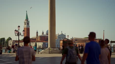 Tourists-walking-in-San-Marco-Square-in-Venice-in-a-sunny-morning,-in-front-of-a-sign-saying-"Gondola-Service