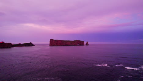 Drone-advancing-towards-Percé-Rock-during-a-cloudy-sunset
