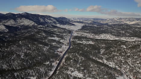 Evergreen-Colorado-Denver-Open-Space-aerial-drone-cinematic-fresh-snow-dusting-cold-white-scenic-landscape-toward-Old-Squaw-Pass-traffic-driving-front-range-sunset-bluesky-forward-motion