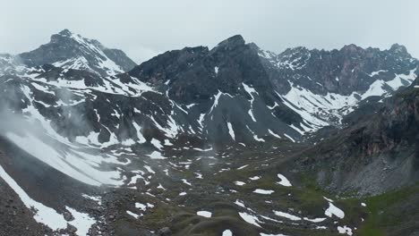 Picos-Montañosos-Brumosos-Con-Nieve-Y-Cascada-De-Stroppia-Cerca-Del-Lago-Niera,-Escena-Natural-Tranquila