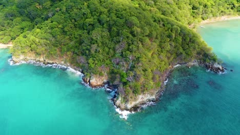 Approaching-drone-shot-descending-over-the-coastal-area-of-Tayrona-National-Park,-in-Colombia,-located-in-South-America