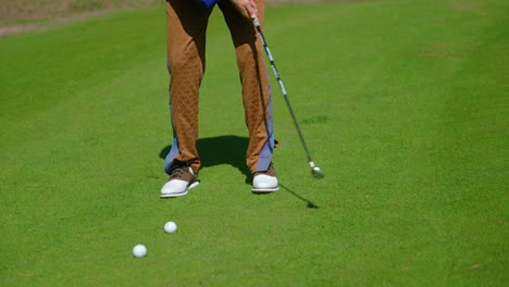 Trendy-young-adult-female-concentrating-putting-row-of-golf-balls-practicing-her-technique