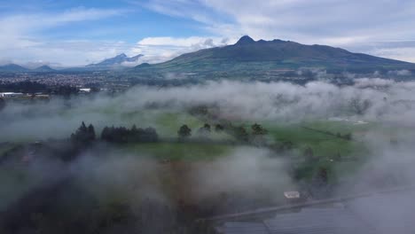 Aerial-Flight-through-the-Clouds-with-View-of-Machachi-City-and-Background-of-Corazón-and-Illinizas-Volcanoes