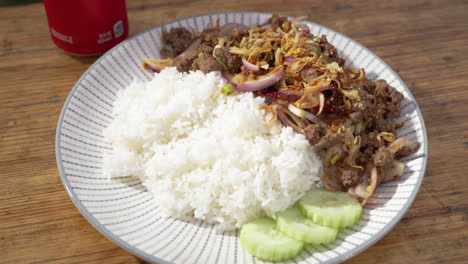 Full-plate-of-beef-larb-with-white-rice-and-sliced-cucumbers,-slider-4K