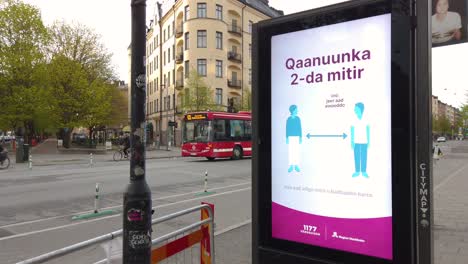 Covid-virus-info-in-different-languages-on-street-sign-in-Stockholm