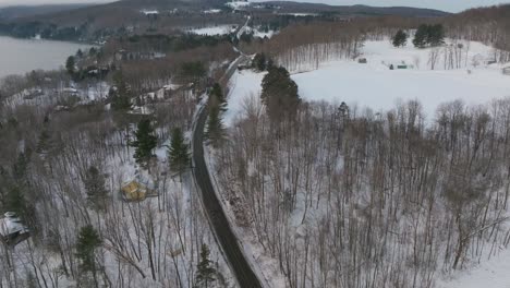 Asphalt-Road-Between-Bald-Tree-Forest-During-Winter-In-Quebec,-Canada