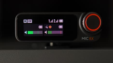 Close-View-Of-DJI-Mic-2-RX-OLED-Screen-Of-Wireless-Mic-Receiver-Show-Variety-Of-Display-Icons-Like-Volume,-Battery-Level-And-Frequency