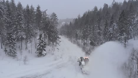 Ein-Traktor-Durch-Eine-Schneebedeckte-Landstraße-Mit-Dichten-Nadelbäumen