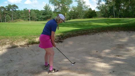 Colorido-Golfista-Adulta-Joven-Saltando-Una-Pelota-De-Golf-Fuera-Del-Peligro-De-La-Trampa-De-Arena