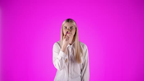 Cute-woman-puts-powder-on-her-nose,-isolated-on-purple-background,-static-shot