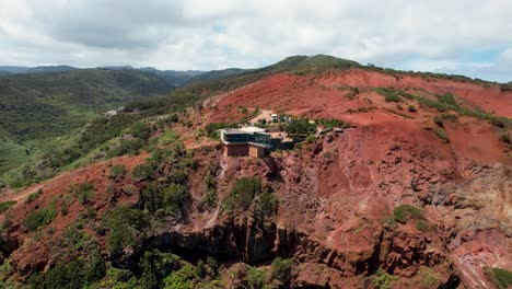 La-Vista-Giratoria-Del-Dron-Revela-El-Mirador-De-Abrante,-Formaciones-Rocosas-Rojas-Y-Un-Telón-De-Fondo-De-Exuberantes-Montañas-Verdes,-La-Gomera