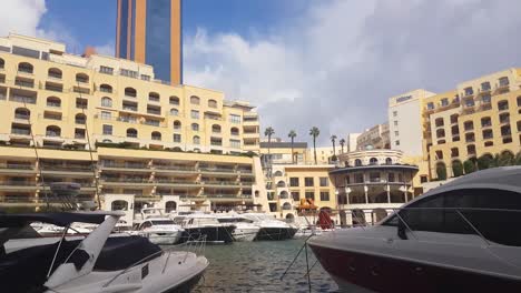 Boats,-yachts-and-luxury-accommodation-in-the-beautiful-Portomaso-Marina,-St,-Julians,-Malta,-tilting-down-establishing-shot