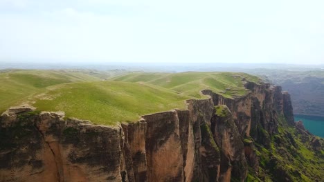 Maravilloso-Paisaje-De-Promontorio-Temporada-De-Verano-Acantilado-De-Roca-Abismo-Naturaleza-Vista-A-La-Montaña-Valle-Del-Cañón-Profundo-Lado-Del-Lago-Atracción-Lateral-Del-Mar-Pasto-Verde-Cubierto-Mar-Azul-En-El-Fondo-Vista-Aérea-Maravillosa