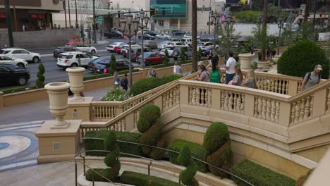 Street-view-of-daytime-Las-Vegas-Boulevard,-people-climbing-stairs-at-Palazzo-entrance