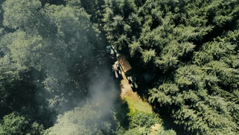 Deforestation-equipment-and-tractor-in-a-forest,-aerial-view