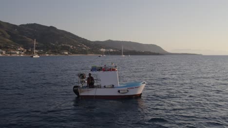 Vista-Aérea-Del-Barco-Pesquero-En-El-Mar-Mediterráneo-Al-Atardecer,-Sicilia,-Italia