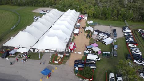 People-enjoying-themself-at-the-annual-Polka-fest-in-Cedar-Michigan,-USA,-Aerial-close-sideways-drone-shot