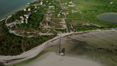 Aerial-shot-of-a-small-village-revealing-the-beach-and-the-sea