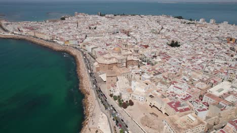 Panorama-Drohnenvideo-Mit-Schwenkbewegung-Der-Kathedrale-Von-Cadiz,-Der-Altstadt-Und-Der-Küste-An-Sonnigen-Tagen