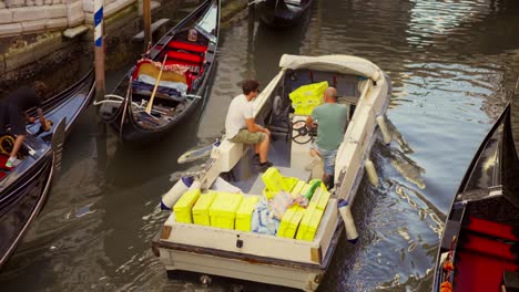 Zwei-Männer-Fahren-Ein-Boot-In-Den-Kanälen-Von-Venedig,-Italien