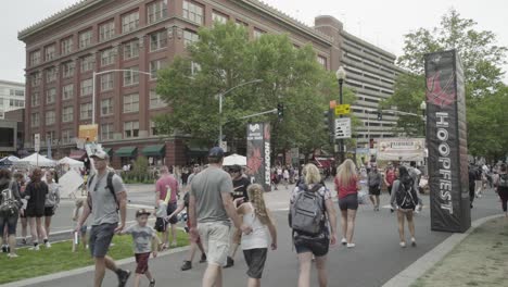 Hoopfest-2018-–-Weite-Aufnahme-Einer-Menschenmenge,-Die-Im-Hintergrund-Am-Hoopfest-Schild-Vorbeigeht