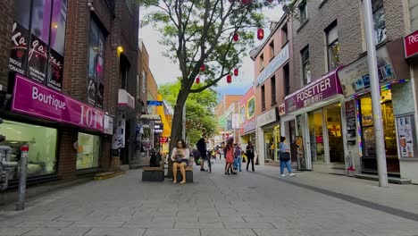 Nach-Covid19-Herrscht-In-Montreals-Chinatown-Reges-Treiben,-Da-Die-Menschen-An-Einem-Sommertag-Schaufensterbummel-Machen,-Während-Kleine-Gruppen-Von-Touristen-Aus-Dem-Ausland-Abreisen