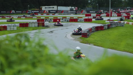 Pista-De-Karts-De-Circuito-Húmedo-Durante-La-Carrera,-Bokeh-De-Hierba