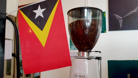 Bandera-De-Timor-Oriental-Y-Granos-De-Café-Timorenses-En-La-Cafetería-Local-En-La-Ciudad-Capital-De-Timor-Oriental,-En-El-Sudeste-De-Asia