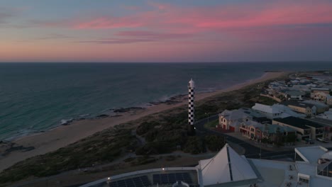aerial-view-over-Bunburry-lighthouse-at-sunset-with-pink-clouds-in-the-background