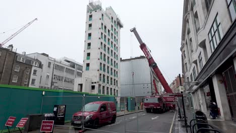 Red-Mobile-Crane-Preparing-To-Lift-In-Wells-Street,-London-On-Overcast-Day