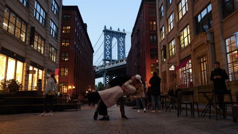 Una-Pareja-Se-Abraza-Con-Un-Chapuzón-En-La-Ciudad-De-Nueva-York,-El-Puente-De-Brooklyn-Al-Fondo