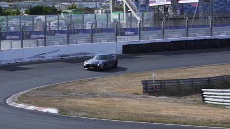 Coche-Plateado-A-La-Deriva-En-El-Circuito-De-Carreras-Oficial,-Quemando-Goma-Y-Genera-Humo.