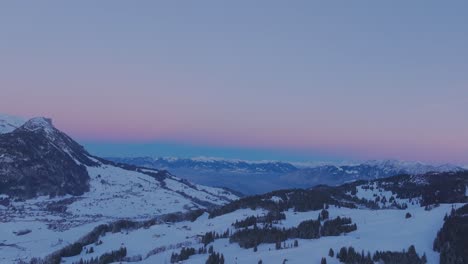 Drohnenaufnahmen-Zeigen-Die-Ruhige-Schönheit-Des-Sonnenaufgangs,-Der-Die-Silhouette-Einer-Schneebedeckten-Bergkette-Erhellt