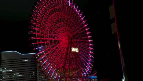 Illuminated-red-Ferris-wheel-at-night-with-a-digital-clock-display