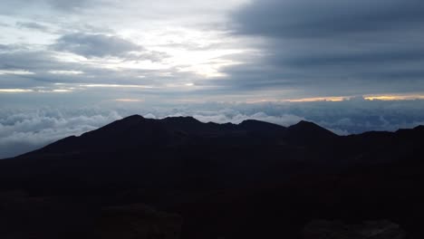 Time-lapse-dawn-with-the-crater-and-puffy-cloud-cover-at-the-top-of-volcano-summit-crater-at-Haleakala-National-Park-which-is-a-massive-shield-volcano,Maui,Hawaii,USA