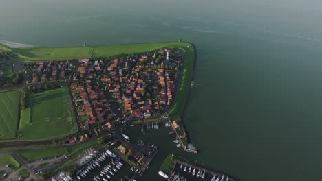 Aerial-drone-view-of-small-village-with-orange-roofs,-Hindeloopen,-Friesland