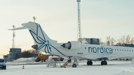 Passagierflugzeug-Nordica-CRJ-900-Geparkt-Auf-Schneebedeckten-Rampe-Am-Flughafen-Tallinn-Während-Winter-Sonnenuntergang