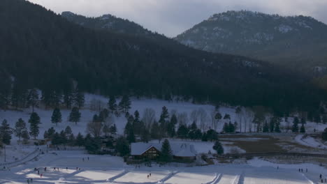 Eislaufen-Schlittschuhlaufen-Eishockeybahn-See-Teich-Eishockey-Winter-Etown-Evergreen-Lake-House-Denver-Golfplatz-Colorado-Luftaufnahmen-Filmdrohne-Sonnenuntergang-Goldene-Stunde-Winter-Neuschnee-Schatten-Zoom-Rückwärts-Schwenk-Nach-Oben