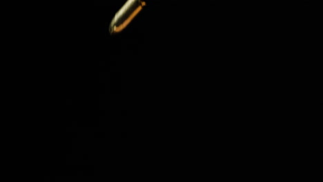 Pieces-Of-9mm-Bullets-Dropping,-Isolated-In-Black-Background