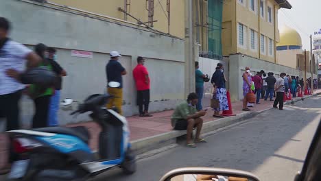 Driving-Past-People-Queing-And-Social-Distancing-In-Colombo,-Sri-Lanka