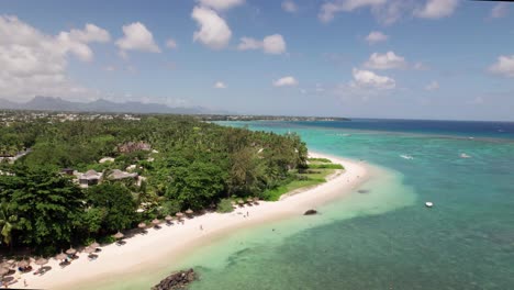North-Beach-Auf-Mauritius,-Türkisfarbenes-Wasser-Plätschert-An-Weißen-Sand,-übersät-Mit-Sonnenanbetern-Und-Palmen,-Luftaufnahme
