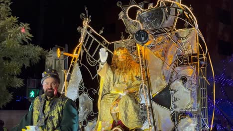 Wizard-king-on-a-running-float-greeting-people-and-children-while-throwing-candy-at-Christmas-in-Barcelona