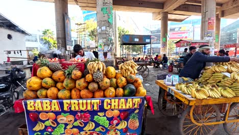 Indian-merchants-selling-religious-fruit-chaat-while-incense-burns-from-shivling-near-Sikanderpur-metro-station,-gurgaon,-india