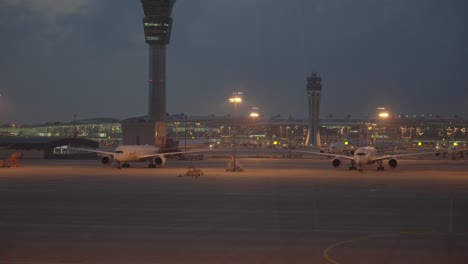 Two-aeroplanes-standing-still-at-Ninoy-Aquino-International-Airport-during-cloudy-evening-