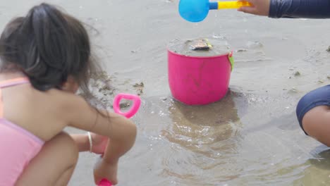 Two-Asian-children-playing-on-the-sand-at-a-beautiful-beach