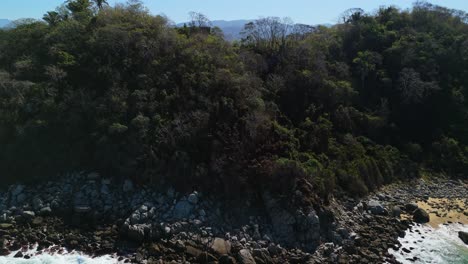 Drone-revealing-Sayulita-town-as-it-flys-over-mountain-cliff-top