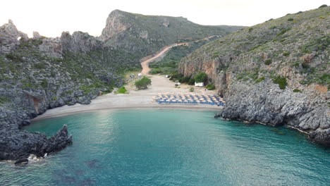 Chalkos-Beach-in-Kythera,-Greece,-boasts-sunbeds-and-sun-umbrellas-on-its-sandy-shore